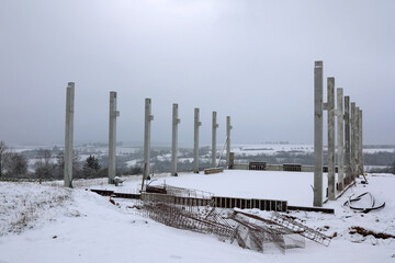 Construction site in winter. Piles for the future building