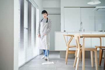 部屋の床を掃除する若い女性