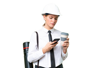 Young architect caucasian woman with helmet and holding blueprints over isolated background holding coffee to take away and a mobile