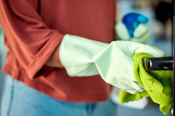 Hand, woman and sanitizing with spring cleaning a door handle surface with a cloth. Busy with...