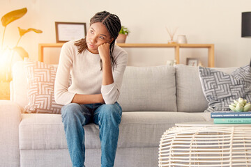 Obraz premium Stress, thinking or burnout black woman in living room. of house or home with sun lens flare light on sofa. Focus, sunshine or girl sitting on lounge couch with depression, anxiety or mental health