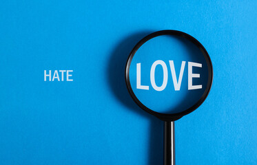 Concept of relationship, choice. Words Hate, Love and magnifying glass on blue background, top view