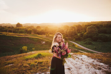 woman with a bouquet of flowers at sunset
