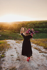 woman with a bouquet of flowers at sunset
