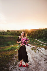 woman with a bouquet of flowers at sunset
