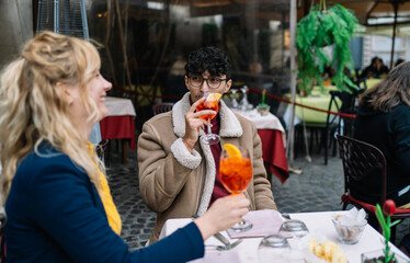 Selective focus on a young Arab boy sitting with his friend while they're having drinks