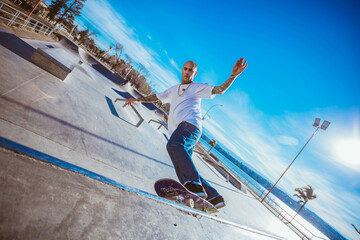 Young man doing skateboarding trick. Man at skatepark on a skateboard.