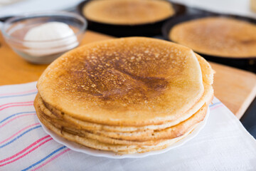 stack of appetizing flour pancakes in the kitchen during cooking