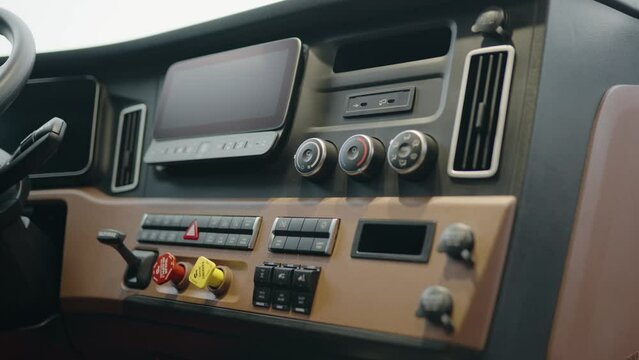 inside in cabin of a new freightliner cascadia Volvo 2023 Semi Truck. Clean dashboard with modern controls. Visible: Parking brakes, screen, temperature controlls, usb chargher, 12 v