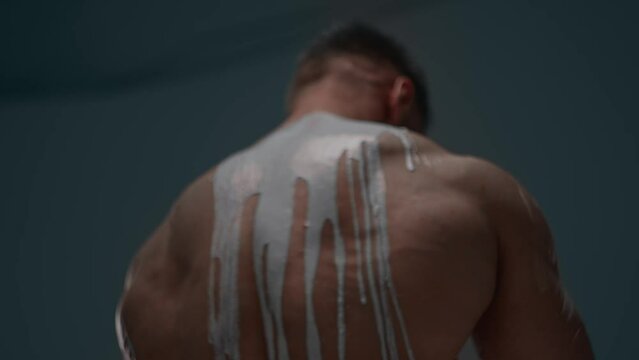 Faceless athletic man turned with his back with white paint