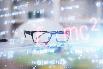 Formulas drawing with glasses on the table background. Concept of science. Double exposure.