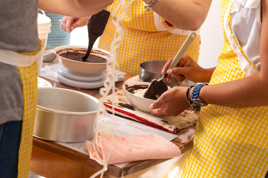 Women at a patry course mixing ingredients to make a cake. Cooking a chocolate cake at the kitchen.