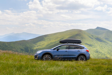 Blue off road car on mountain trail. Traveling by auto, adventure in wildlife, expedition or...