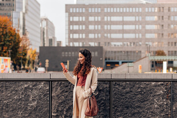 elegant woman using mobile phone in city