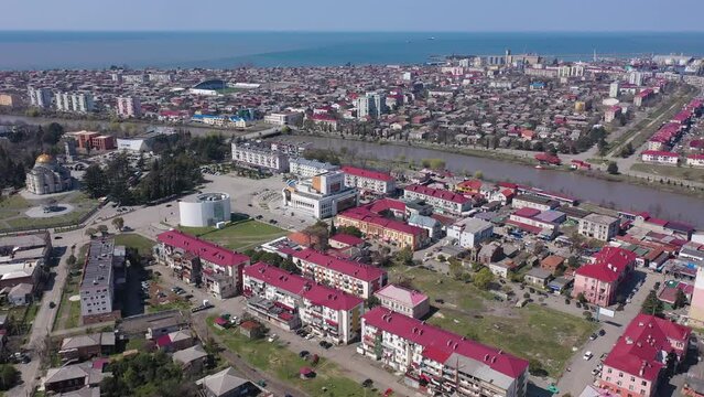 View from drone of modern landscape of Georgian port city of Poti overlooking residential areas and Orthodox Cathedral in Neo-Byzantine style on sunny spring day, Samegrelo-Zemo Svaneti region