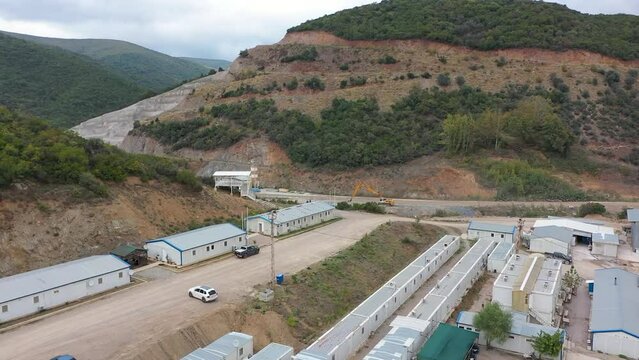 Aerial view of metal container houses in dam construction work site.