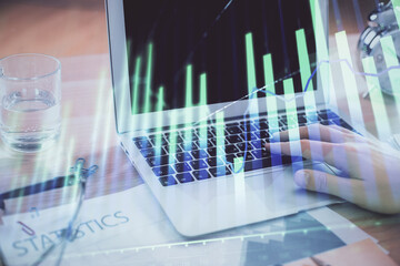 Multi exposure of market chart with man working on computer on background. Concept of financial analysis.