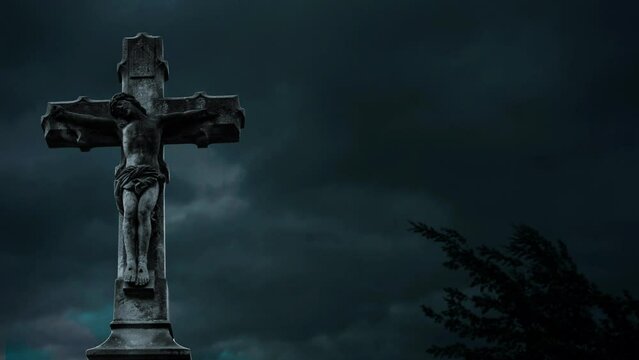 religious cross in a cemetery and dramatic stormy sky behind