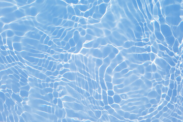 Fototapeta na wymiar Defocus blurred transparent blue colored clear calm water surface texture with splashes and bubbles. Trendy abstract nature background. Water waves in sunlight with caustics. Blue water shinning 