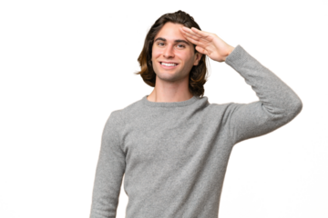 Young caucasian man isolated on green chroma background saluting with hand with happy expression
