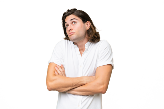 Young caucasian man isolated on green chroma background making doubts gesture while lifting the shoulders