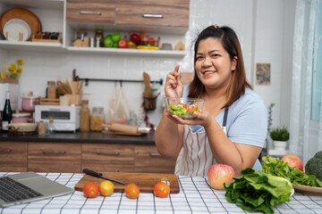 Asian Pregnant learn how to cook healthy meals from the Internet in kitchen, Fat women prepare a vegetable salad for diet food and lose weight. Concept of healthy eating