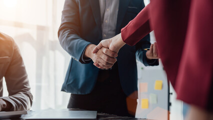 Group business workers handshake at meeting at office meeting room, from joint investment and success in the project after meeting stock market project.