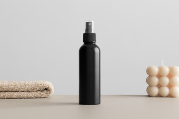 Black cosmetic spray bottle mockup with a candle and a towel on the beige table.