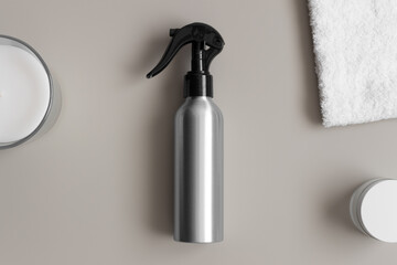 Aluminium cosmetic trigger sprayer bottle  mockup with a towel on the beige table.