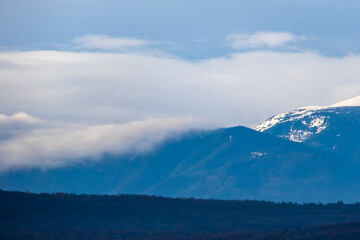 Fototapeta na wymiar mountain pick with snow and heavy clouds in winter season, Bulgaria