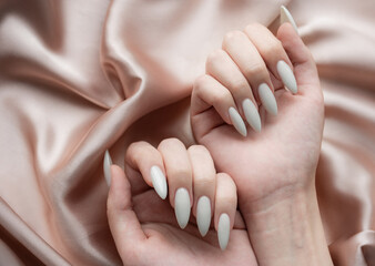 Hands of a young woman with white manicure on nails