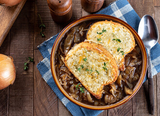 French onion soup with toasted cheese baguette garnished with thyme