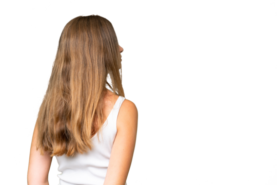 Young pretty woman over isolated background in back position and looking back