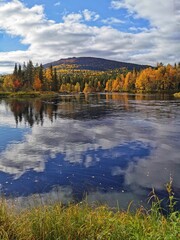 View of Kivakka mountain and colorful trees over Olanga river. Autumn tranquil landscape. Paanajarvi National Park, Karelia.
