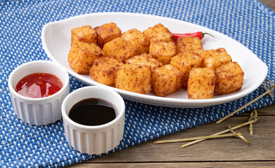 Tapioca dice, typical northeast brazilian food with chilli pepper and sugar syrup over wooden table