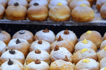 Fresh donuts with chocolate, jam at the bakery display for celebration. Sufganiyot - Israeli Donuts. Selective focus. Symbol of sweet Hanukkah donut - Sufganiyah. 