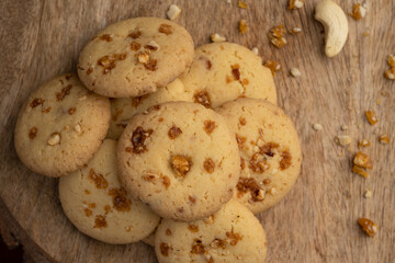 Freshly baked butterscotch cookies with its ingredients like dry fruits on wooden background