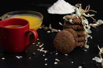 Homemade oatmeal cookies on black wooden table.