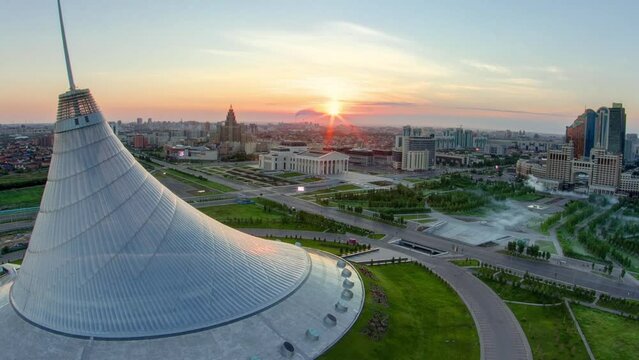 Elevated view with sunrise over the city center with Khan Shatyr and central business district transition aerial timelapse before sunrise time from rooftop, Kazakhstan, Astana, Central Asia