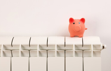 Piggy bank on radiator. Cold home, Global energy crisis concept. Price for electricity and heating...