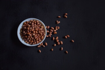 peanuts in a bowl on a dark background