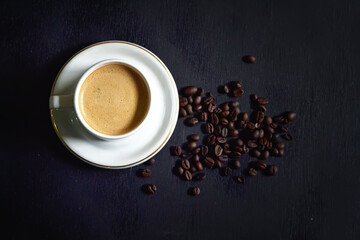 Obraz na płótnie Canvas Hot cappuccino and coffee beans on a dark background