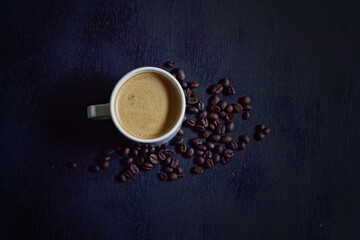 Hot cappuccino and coffee beans on a dark background