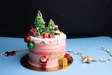 Christmas cake decorated with sweet figures of Christmas tree, Santa, bears, deer, fir-tree