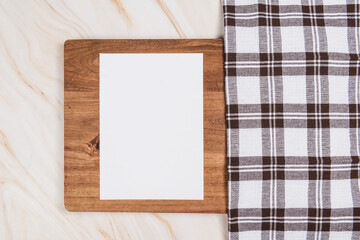 white paper on wood table on marble background with checkered cloth