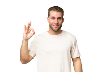 Young handsome caucasian man isolated on green chroma background showing ok sign with fingers