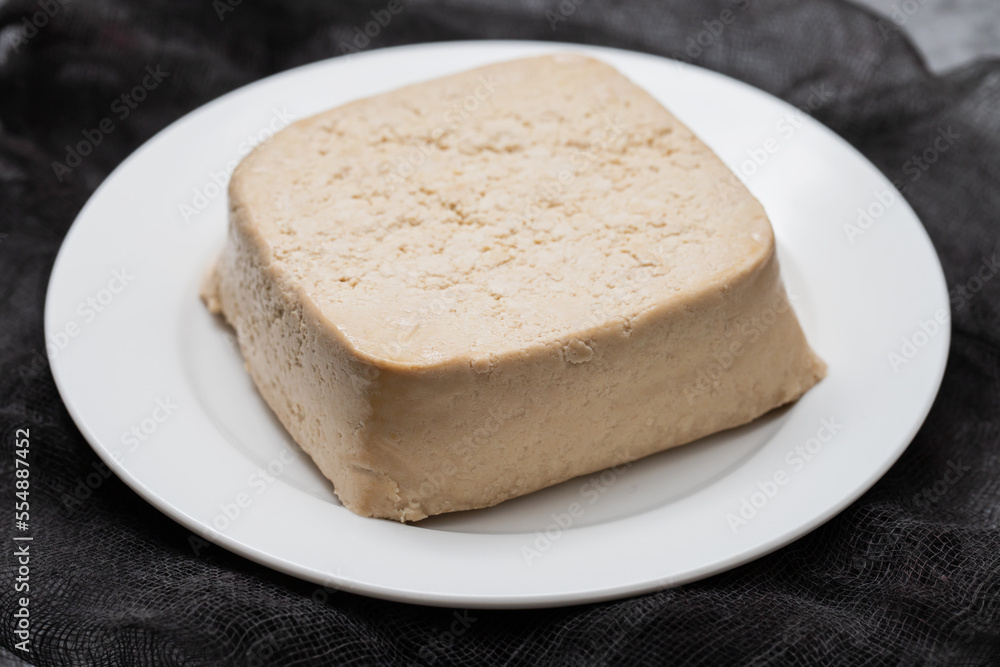 Poster raw tofu block on white small dish on ceramic