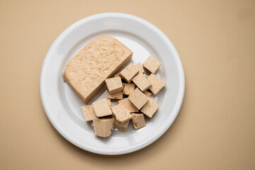 raw tofu block on white small dish on brown