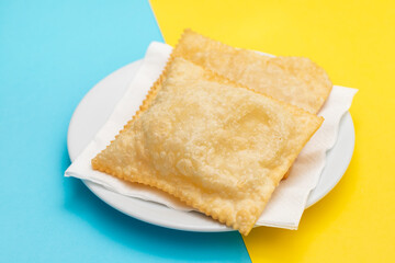 typical brazilian fried pastry on white plate