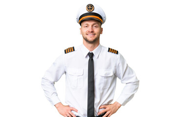 Airplane pilot man over isolated background posing with arms at hip and smiling - obrazy, fototapety, plakaty